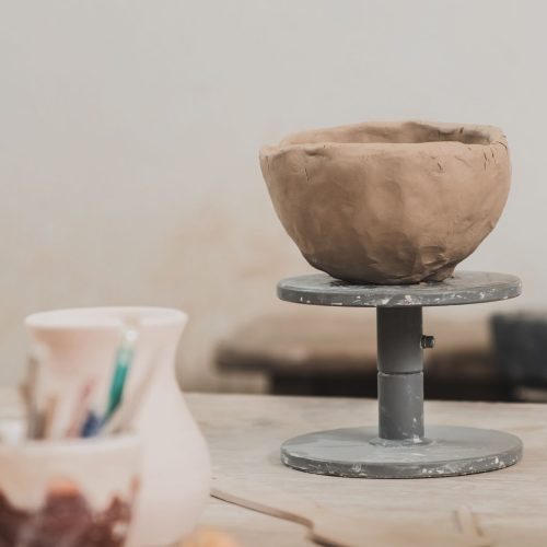 Sculpted-Clay-Bowl-On-Wooden-Table-In-Pottery-Art Sculpted-Clay-Bowl-On-Wooden-Table-In-Pottery-Art